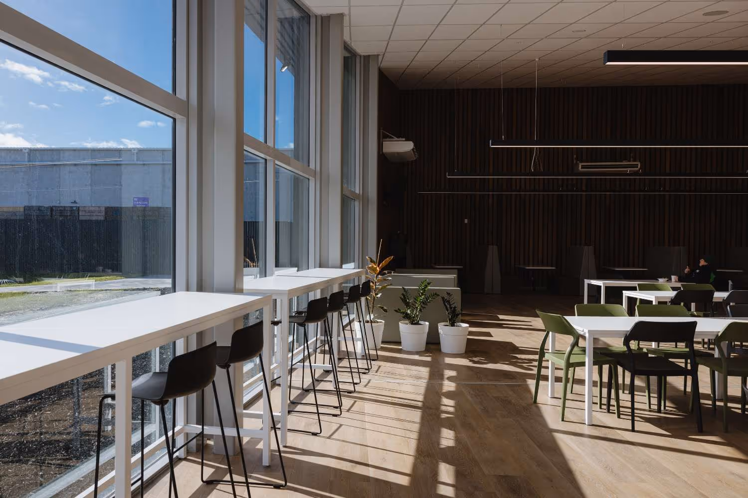 bar leaner with black stools against glass wall