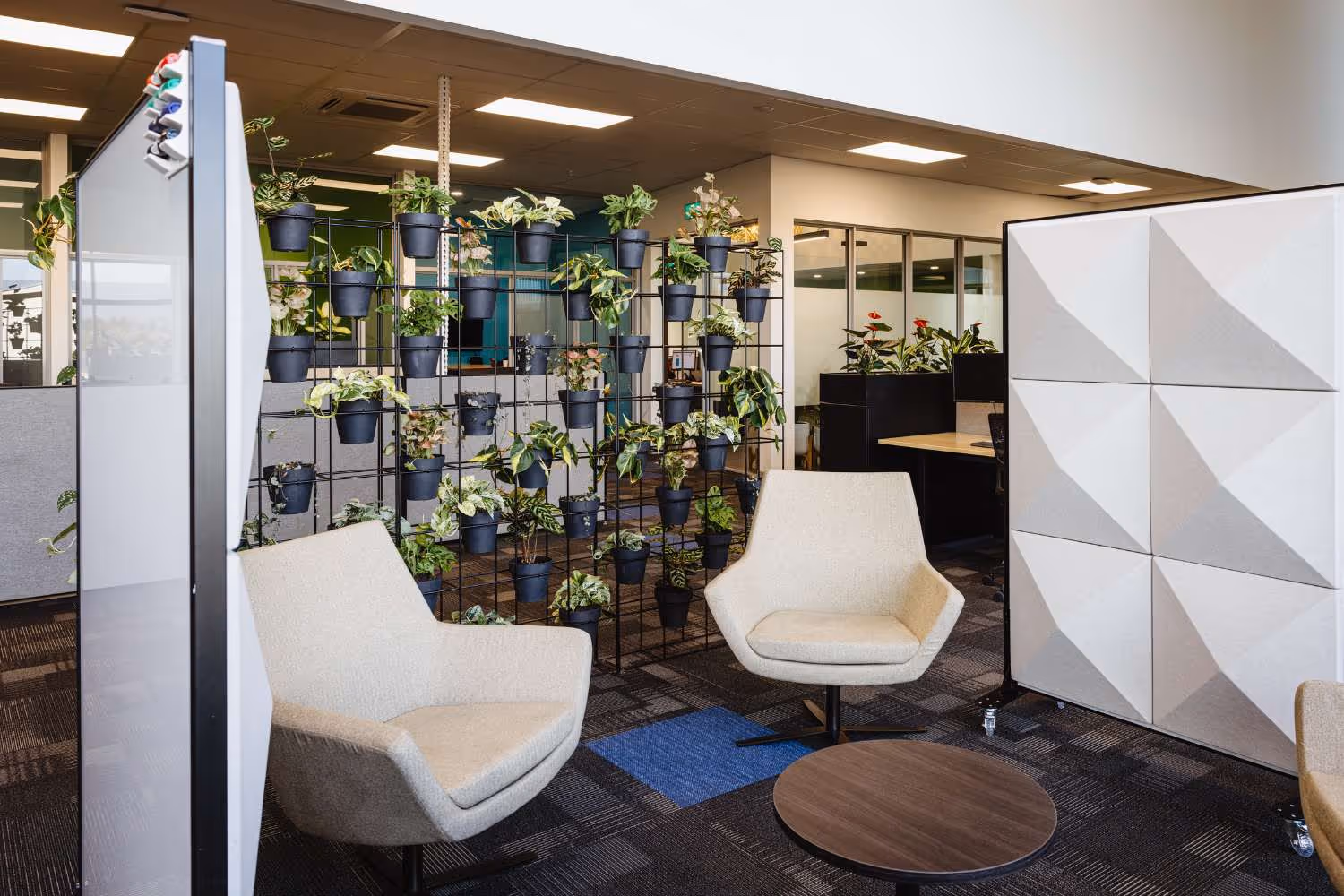 informal meeting space with lounge chairs and plant wall