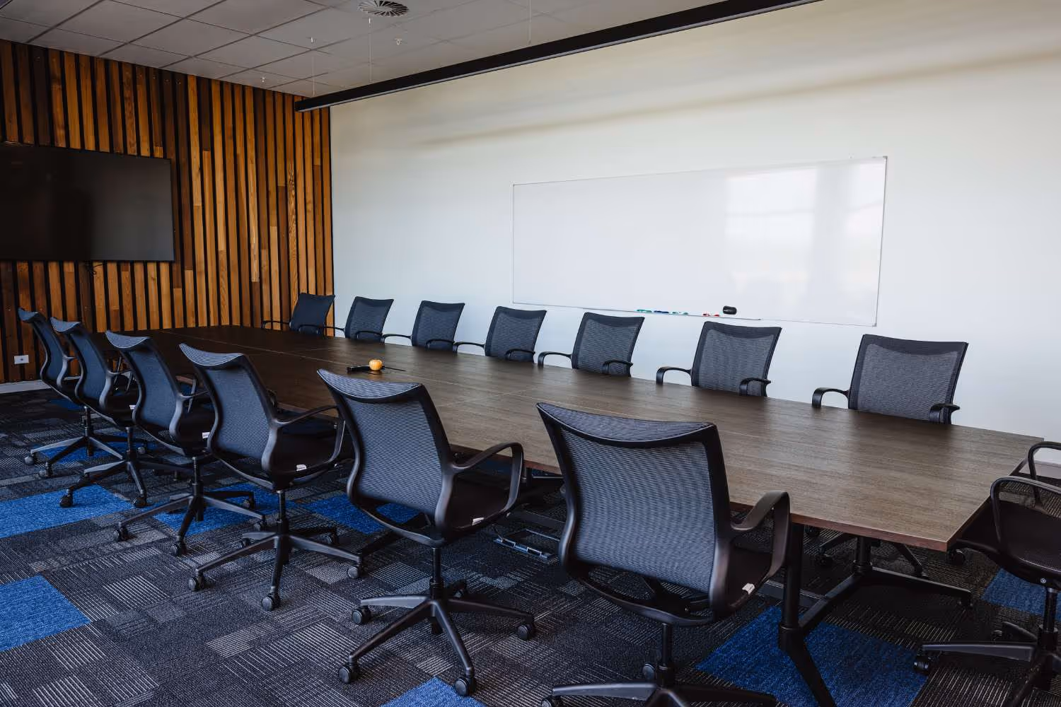 boardroom with large table and mesh back chairs