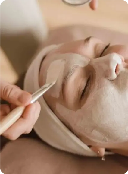 women receiving a facial treatment with a brush-applied face mask