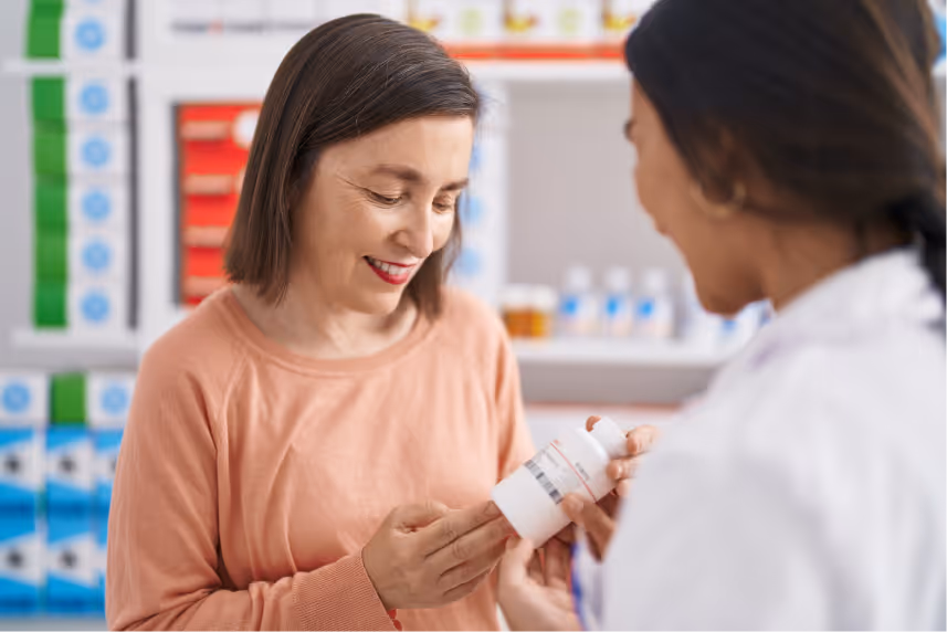 A woman at the pharmacy picking up her prescription.