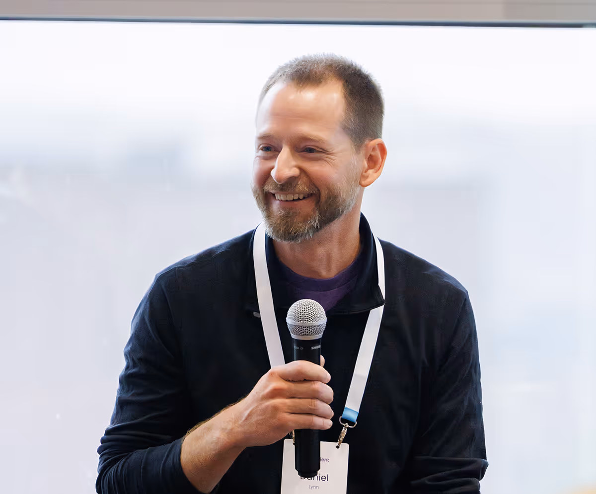 Summit Speaker smiles while speaking to the team.