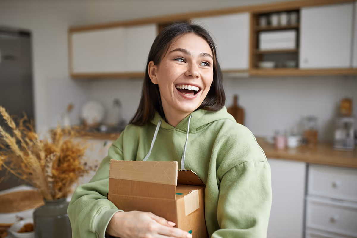 Woman smiling while holding her prescription drug delivery box.