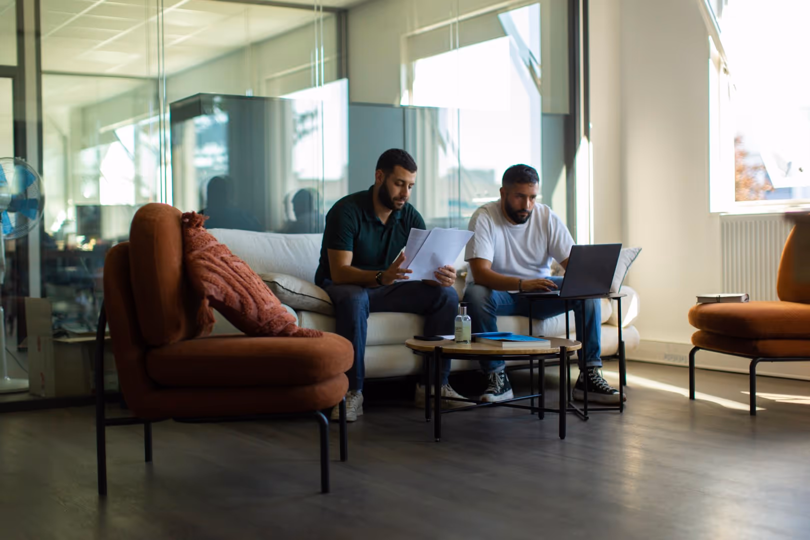 Deux collaborateurs travaillant avec un ordinateur portable et des documents dans un bureau