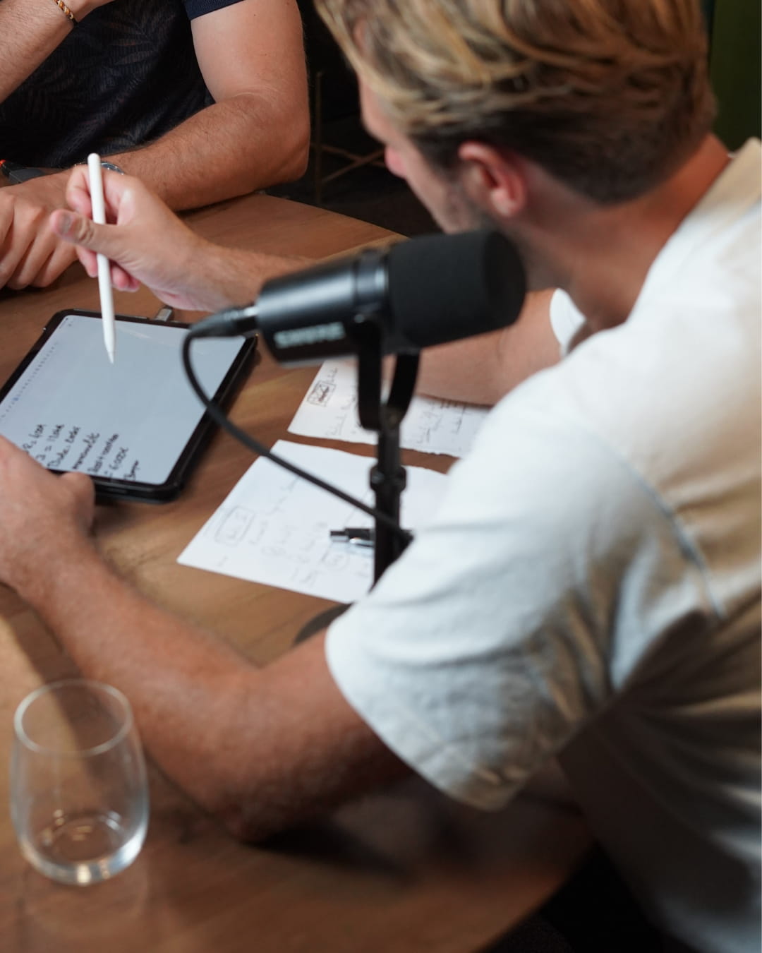Mathieu Lançon en interview au micro, notes et schémas posés sur la table