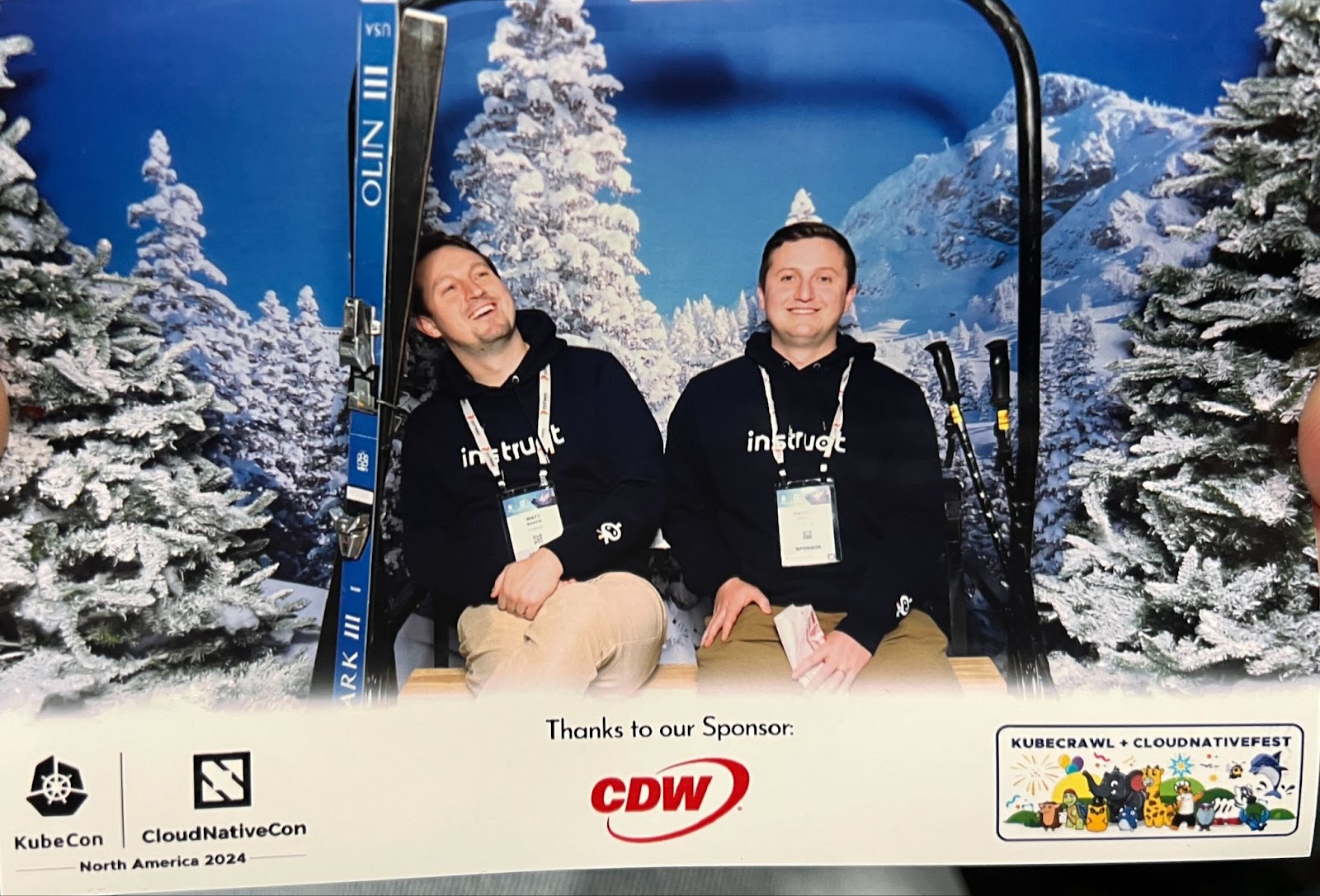Two Instruct-branded attendees pose on a ski lift photo op at KubeCon + CloudNativeCon North America 2024.