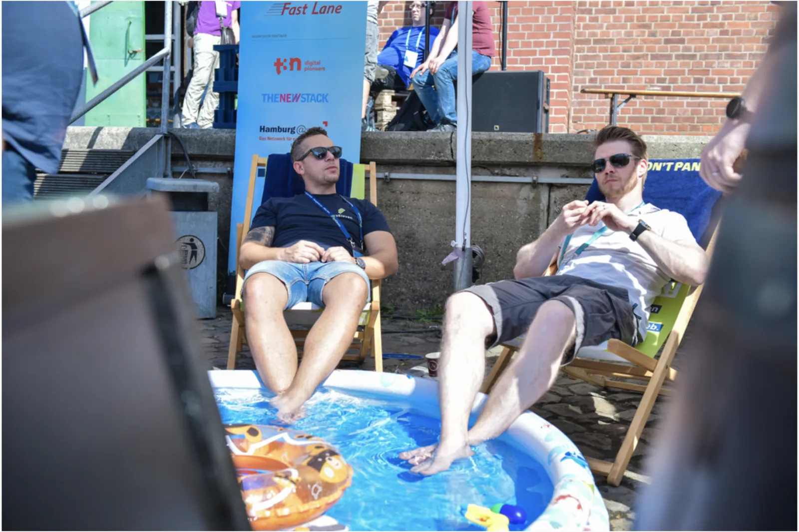 Container Days 2019 attendees relaxing in deck chairs with their feet in a paddling pool