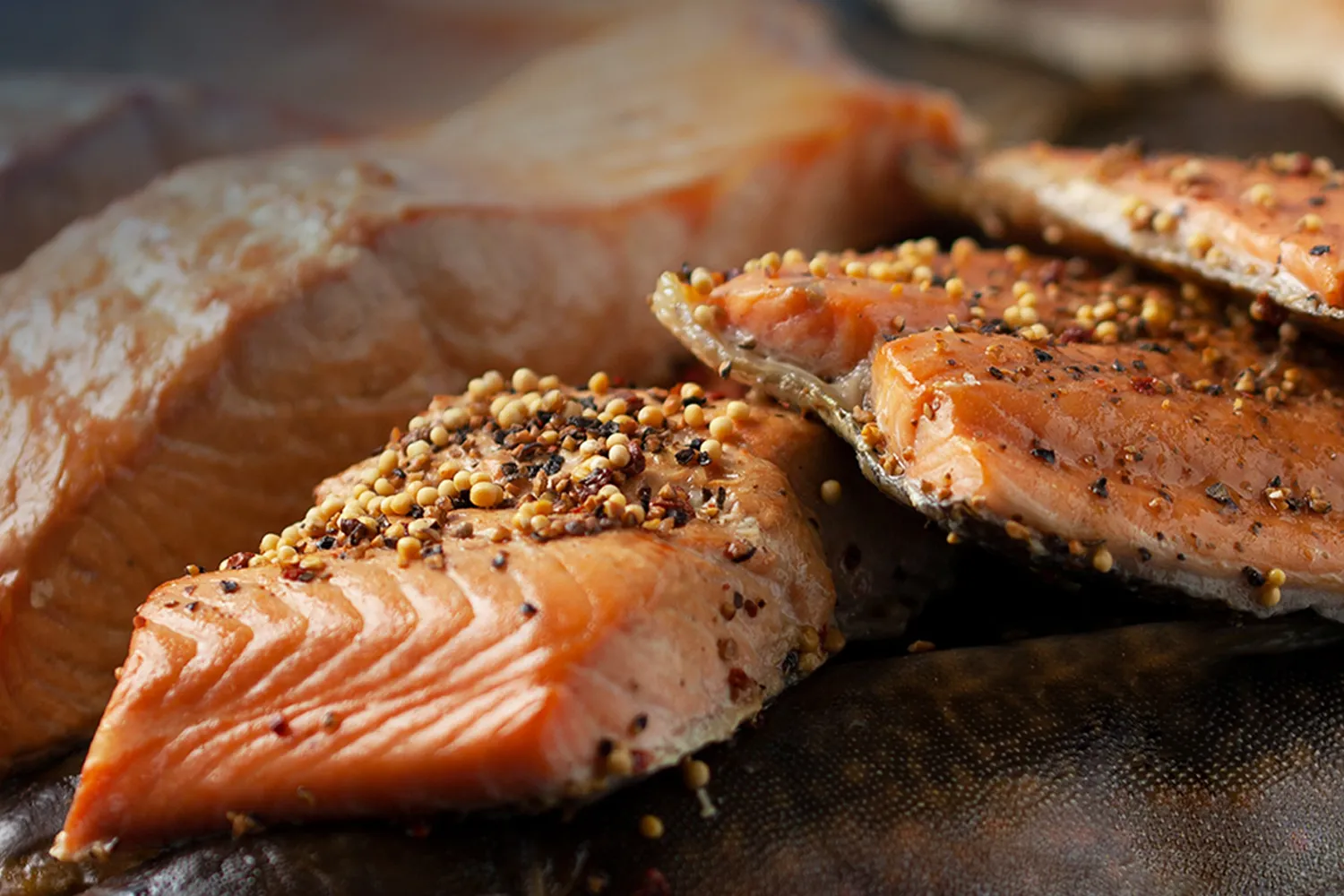 Saftiger, heißgeräucherter Lachs, verfeinert mit aromatischen Pfefferkörnern, die dem Fisch eine würzige Note und ein ansprechendes Aussehen verleihen.
