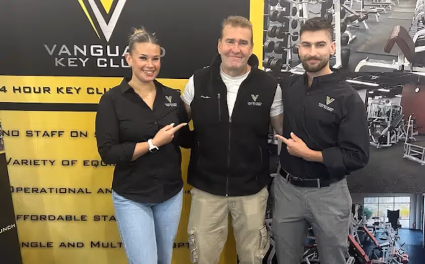 Three Vanguard Key Club staff members pose in fitness gym