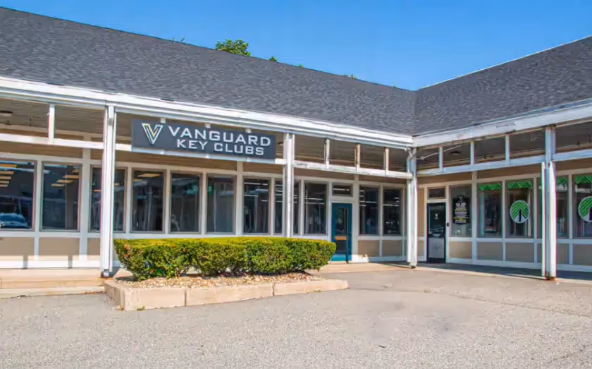 Vanguard Key Clubs storefront with large windows and landscaped entrance