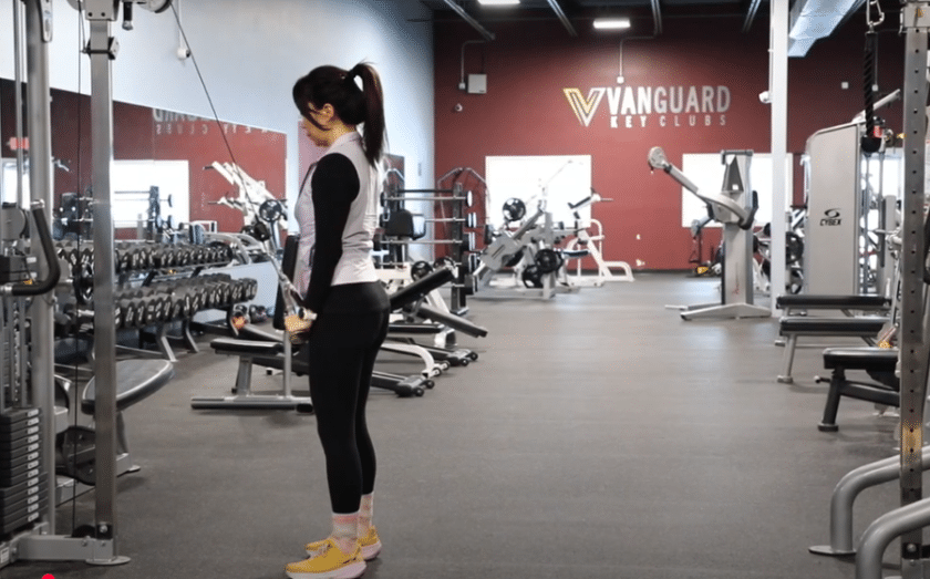 Woman exercising in Vanguard Fitness gym with weight training equipment