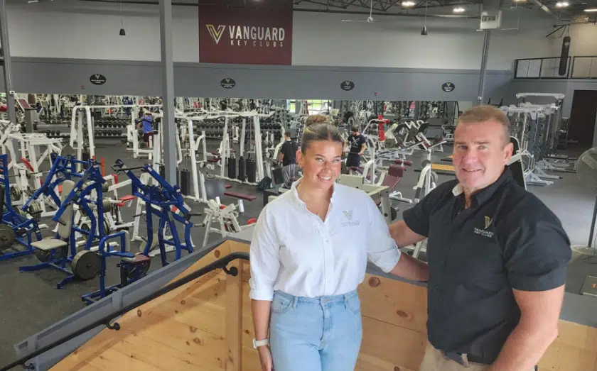 Two staff members standing in Vanguard Key Clubs fitness center with exercise equipment