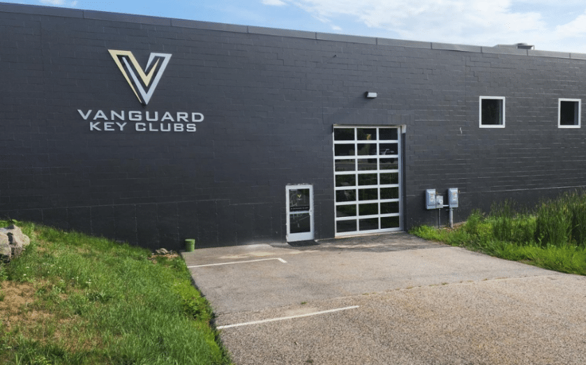 Exterior of Vanguard Key Clubs building with parking lot and glass door