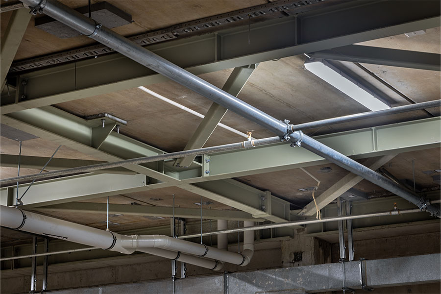 Exposed structural steel ceiling with suspended lighting