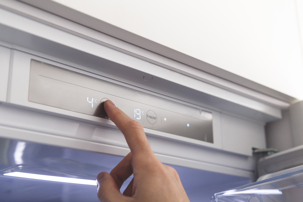 Close up of a hand changing fridge temperature