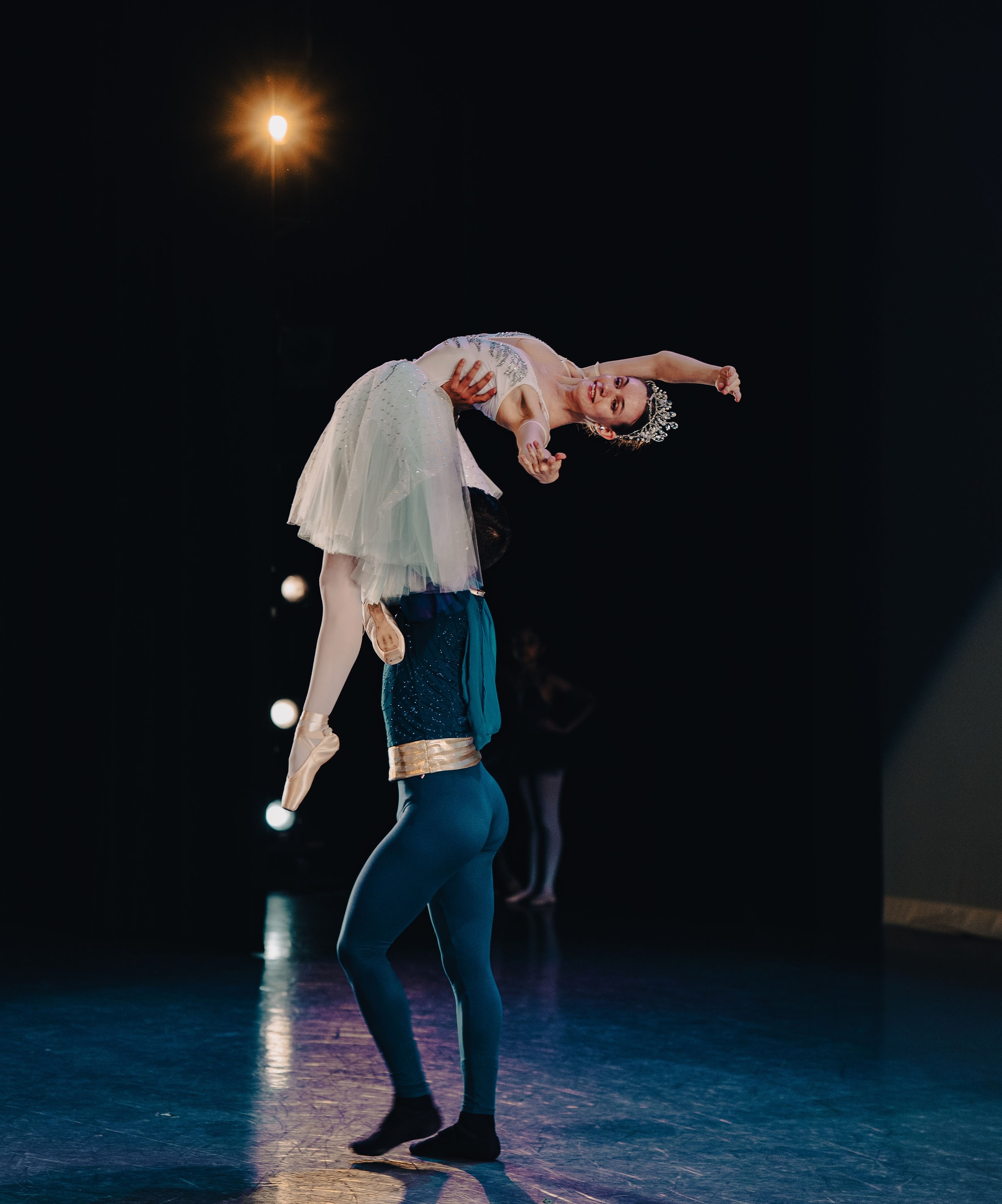 Male ballet soloist lifting female dancer en pointe during a duet at The Russian Ballet School showcase in Toronto, both in classical costume onstage at Betty Oliphant Theatre