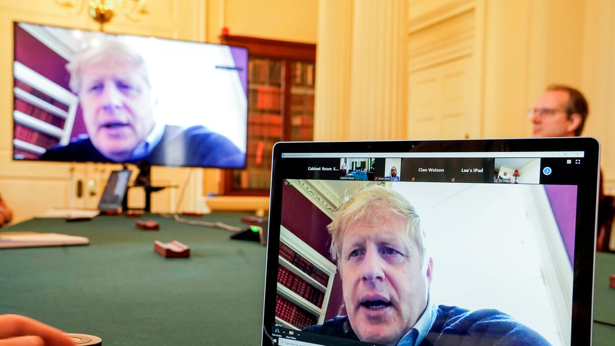 Laptop and TV showing a video call in a meeting room