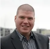 Smiling man in a striped shirt and dark jacket