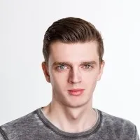 Man with short brown hair in a gray sweater