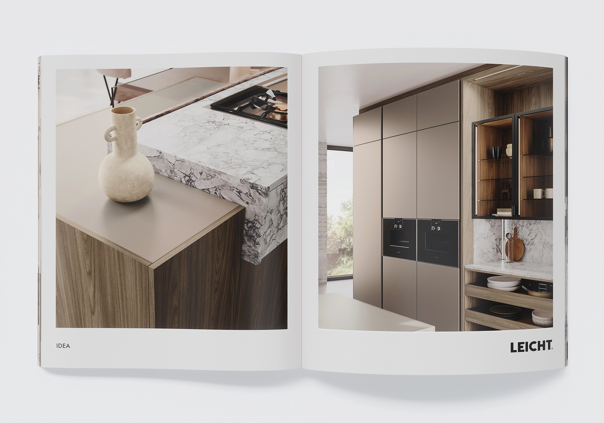 Vista dettagliata dell'isola LEICHT IDEA con piano di lavoro e piano cottura marmorizzati, decori in legno e frontali opachi in seta; a destra la parete del mobile alto con le vetrine VERO.