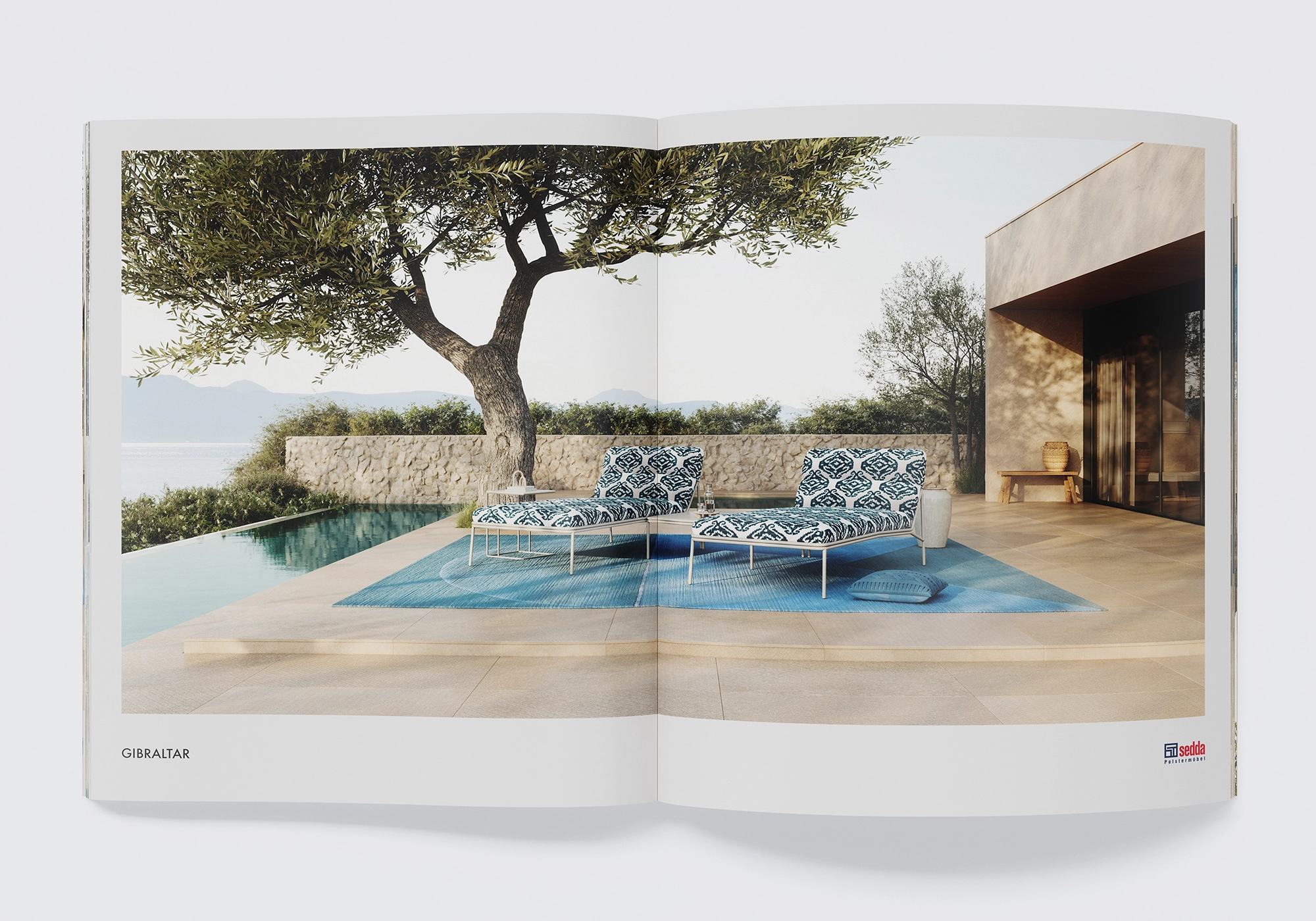 Two "Gibraltar" lounge modules by Sedda by the pool under an olive tree; Mediterranean terrace with stone wall.