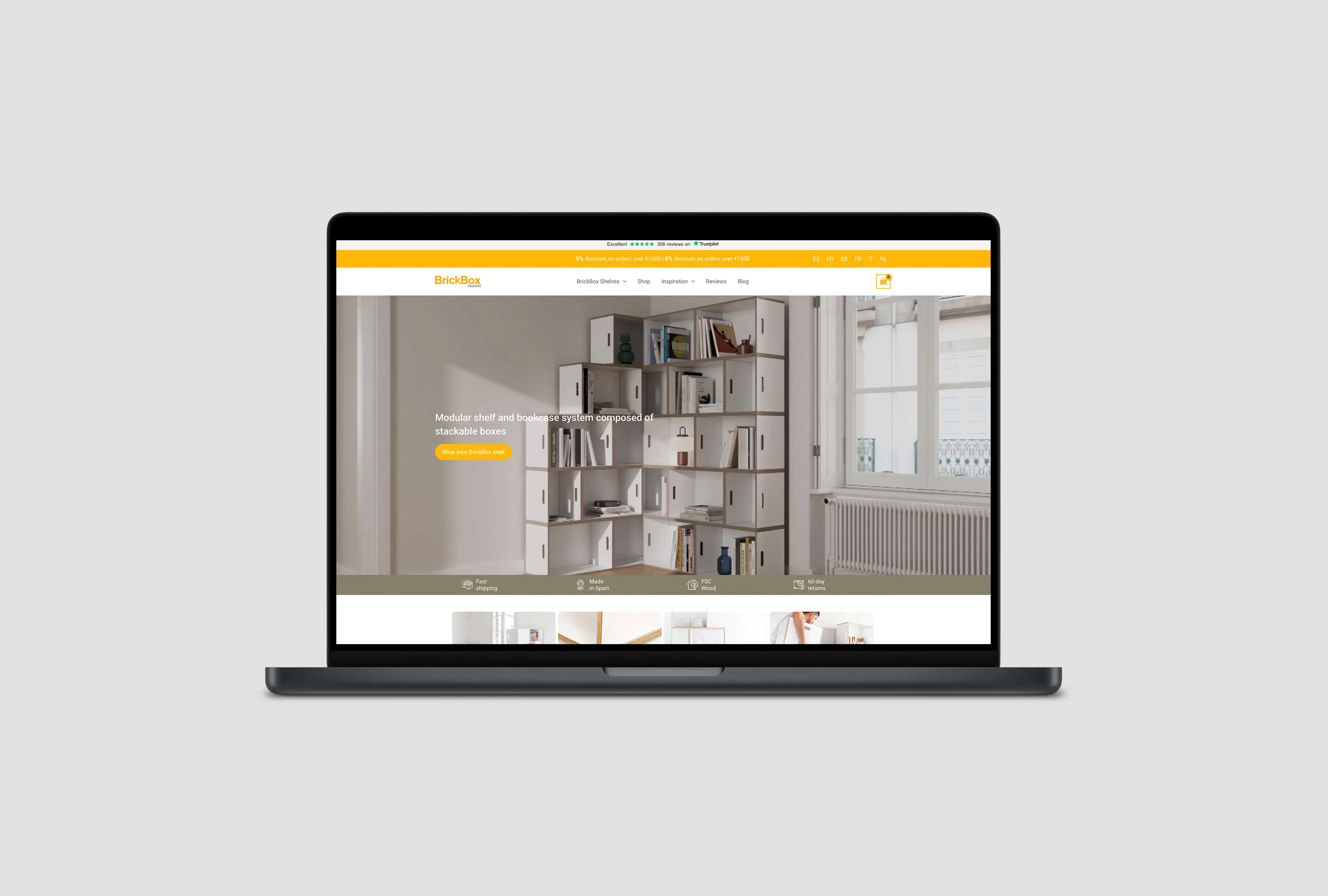 L'ordinateur portable affiche la boutique en ligne BrickBox avec la mise en scène photoréaliste en 3D des systèmes d'étagères modulaires comme image principale.