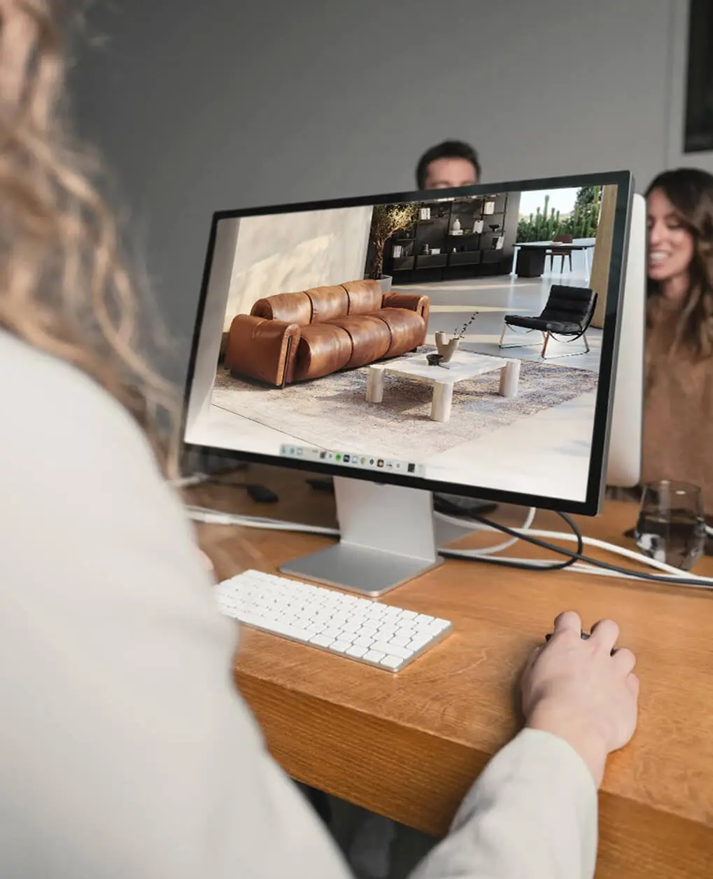 Insight into the CGI workflow: Reviewing a photorealistic 3D rendering of a leather sofa on the monitor for quality assurance.