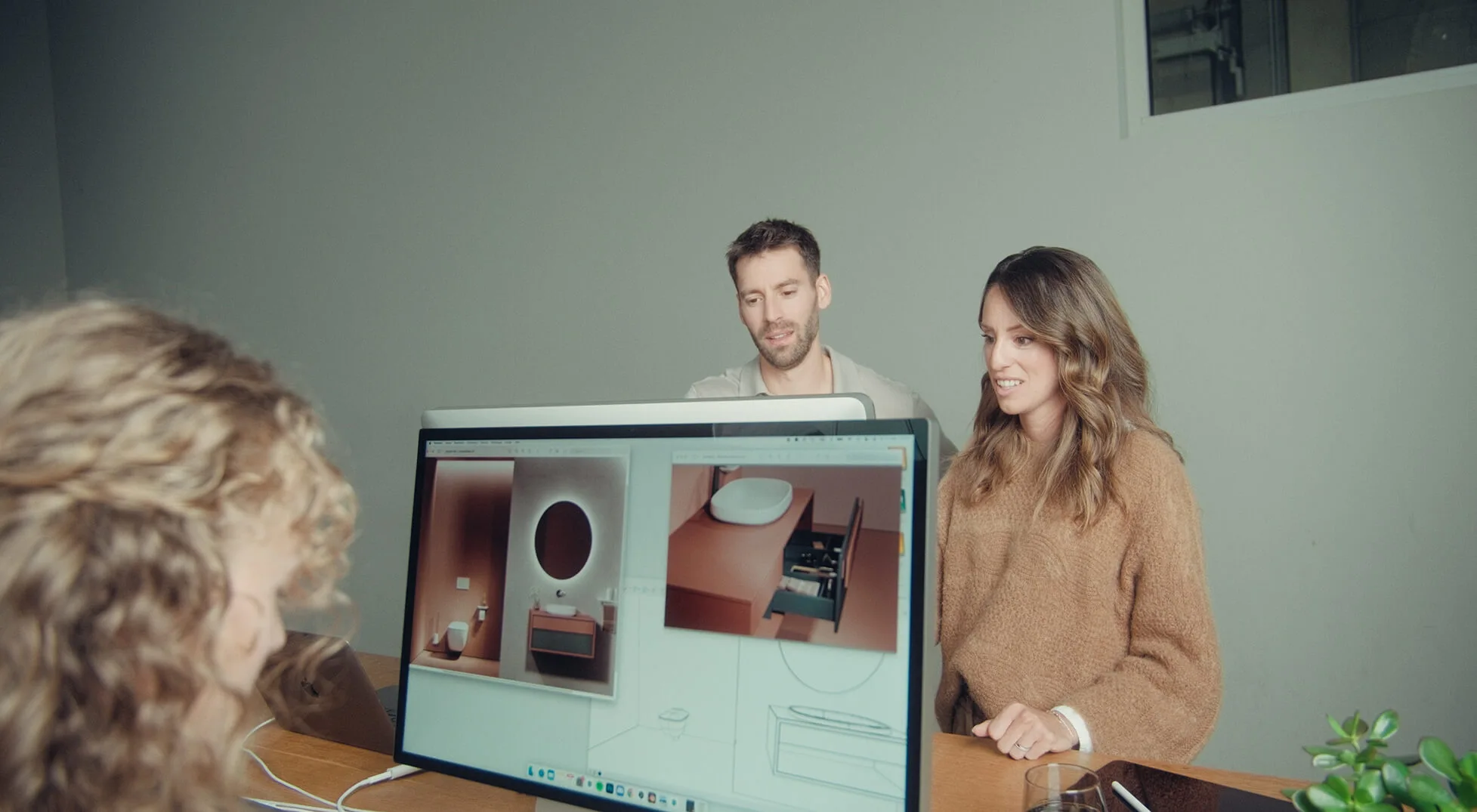 Strategic CGI consulting: The Danthree team discusses details and lighting effects for a photorealistic bathroom visualization on screen.