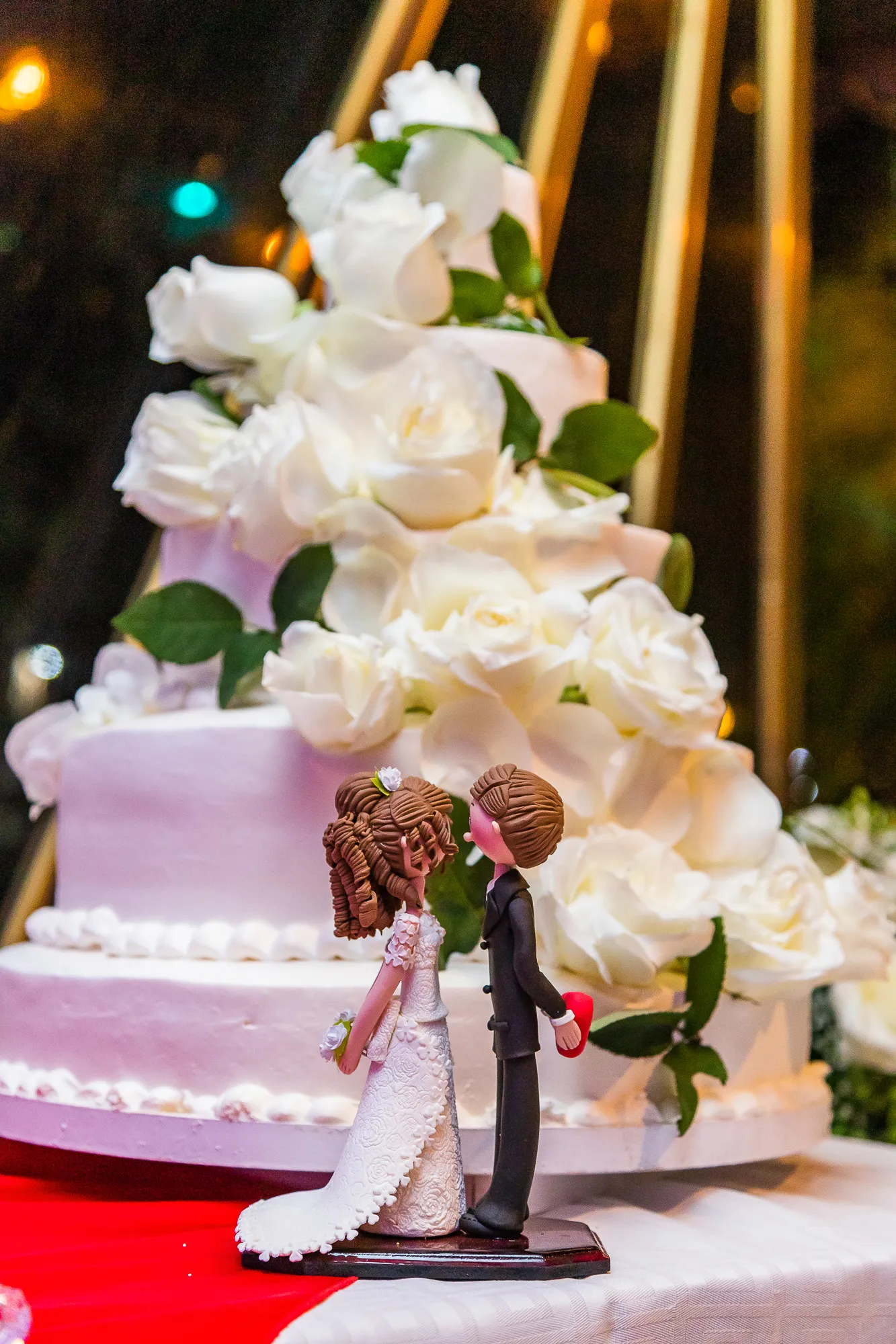 Pastel de boda con flores blancas y figuras de los novios