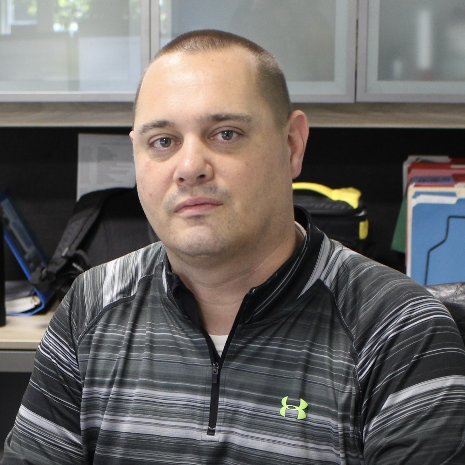 a headshot of our Sales Manager, Marc Slack, he is wearing a grey striped shirt and sitting in an office setting