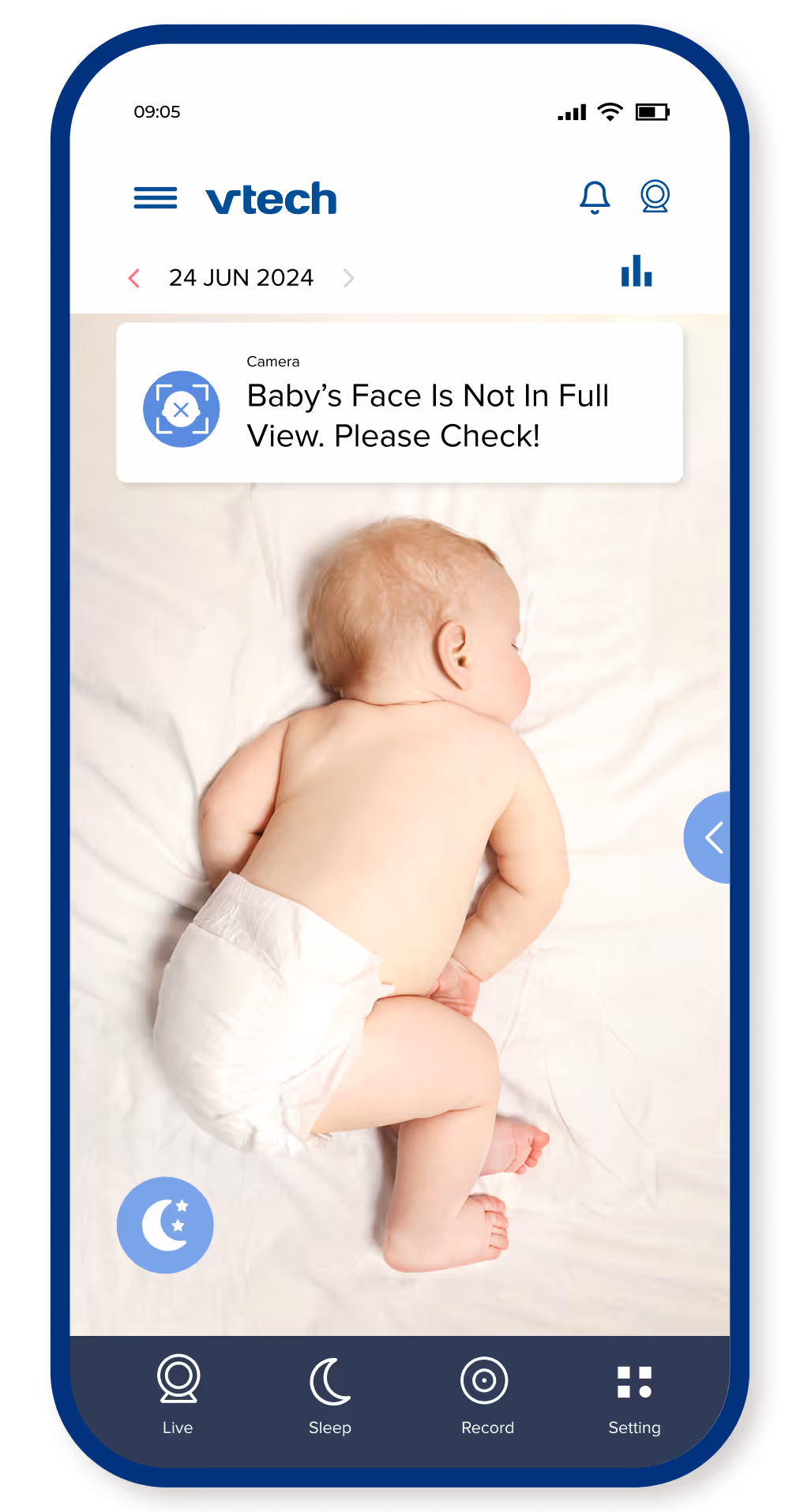 Baby lying on stomach on a white surface, with a camera alert saying the baby's face is not fully visible.