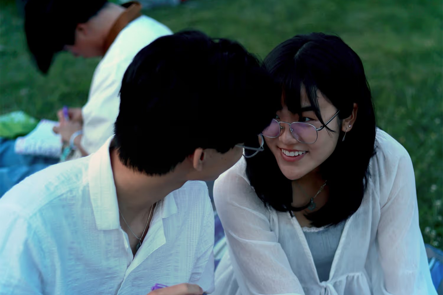 A couple sharing a quiet moment on the grass at Water Lantern Festival