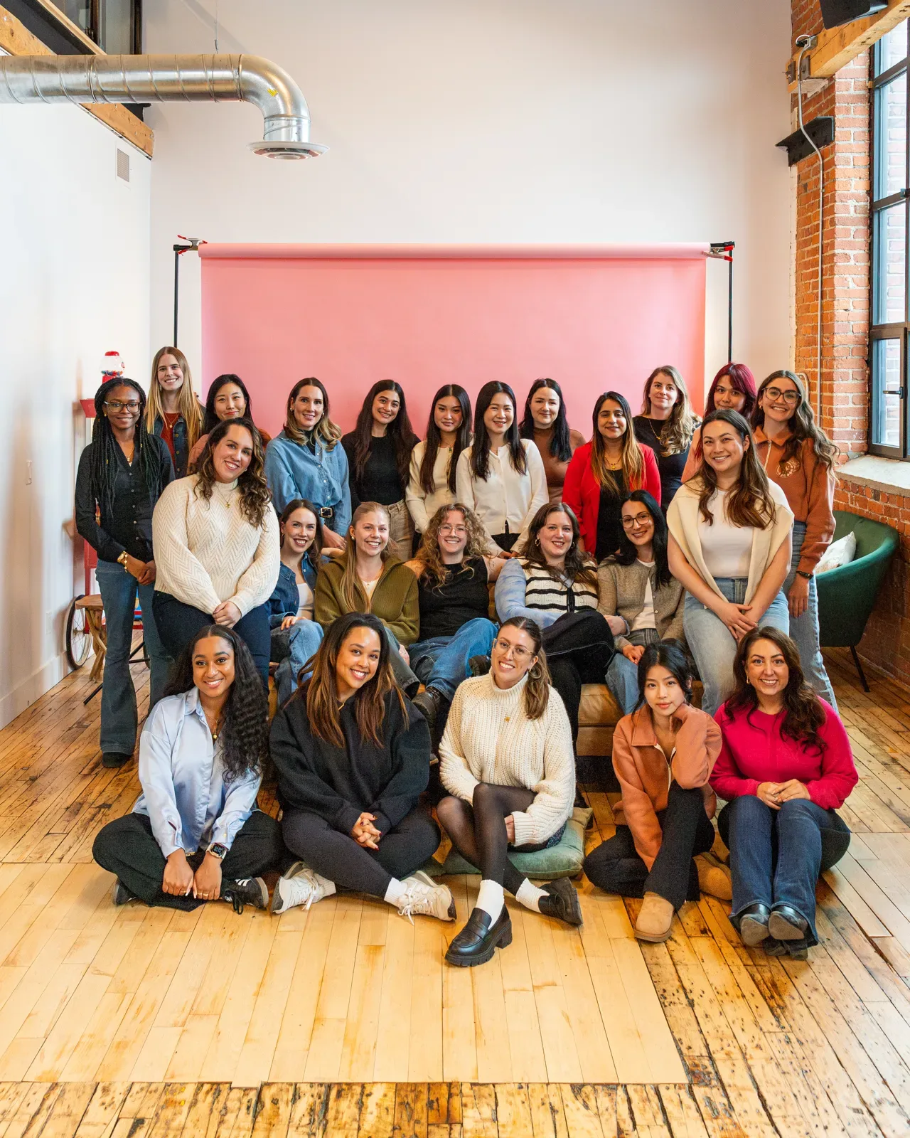 The Influence Agency team in front of a pink backdrop at the Toronto office