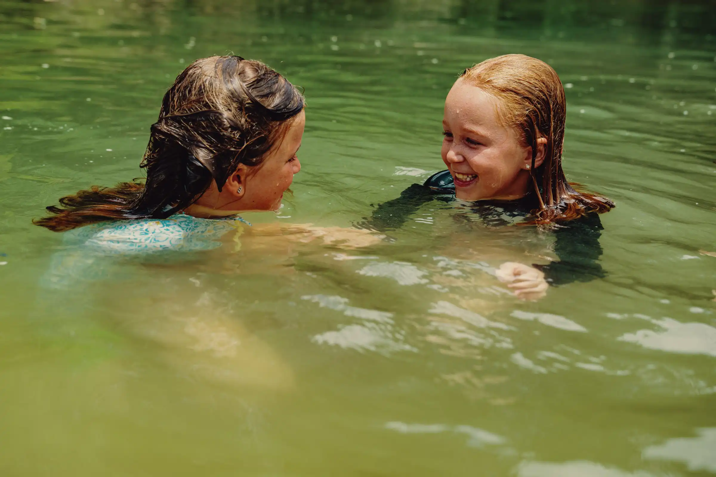 Two campers swimming in the river.