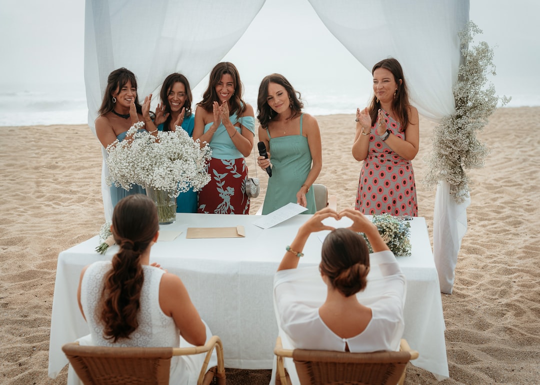 People celebrating a wedding ceremony on a beach.