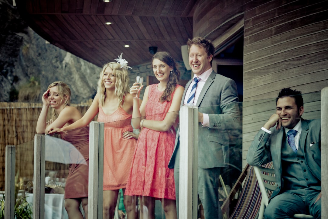 man in gray suit jacket standing beside woman in pink sleeveless dress