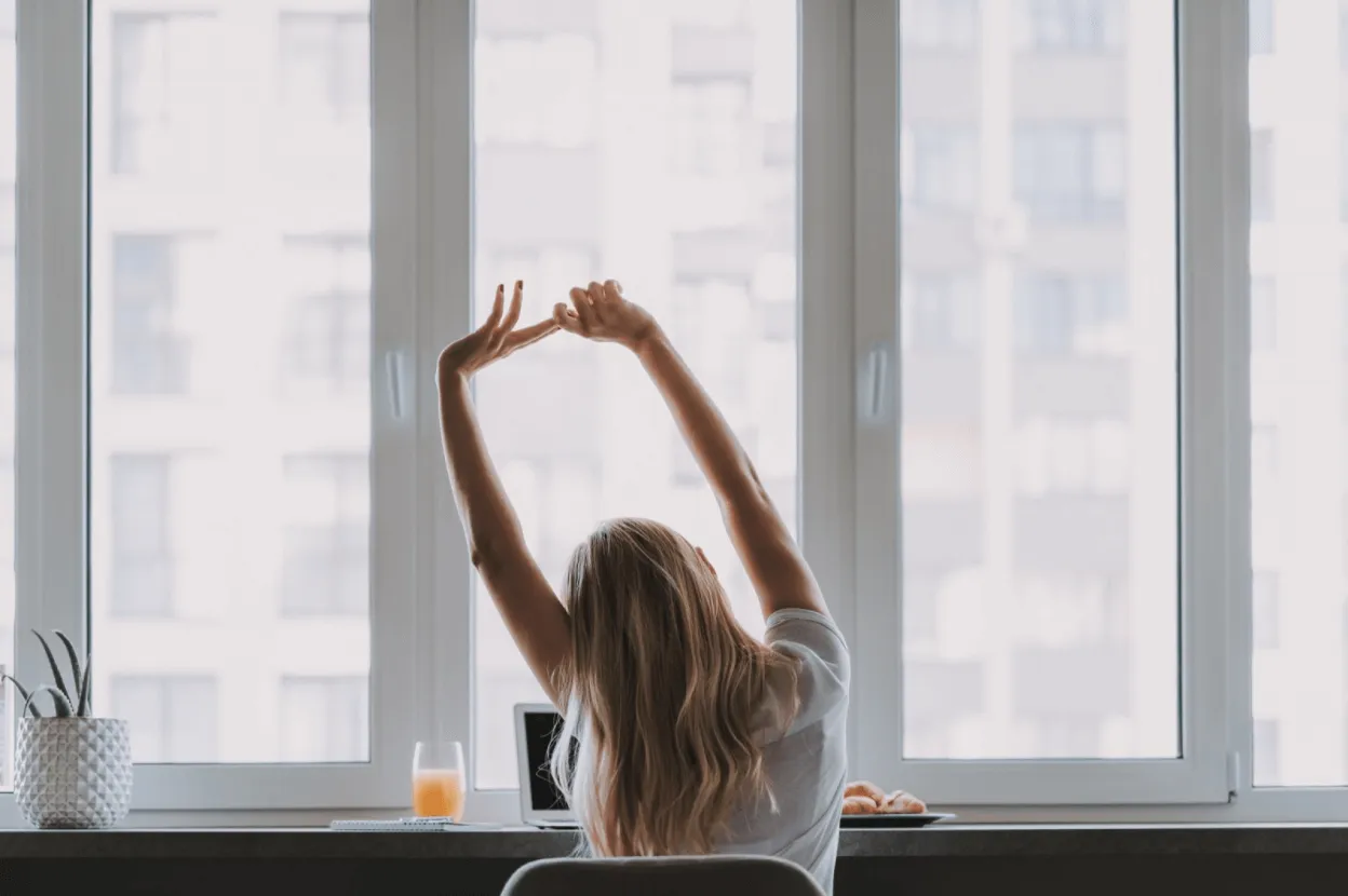 Woman stretching while sitting at her work desk