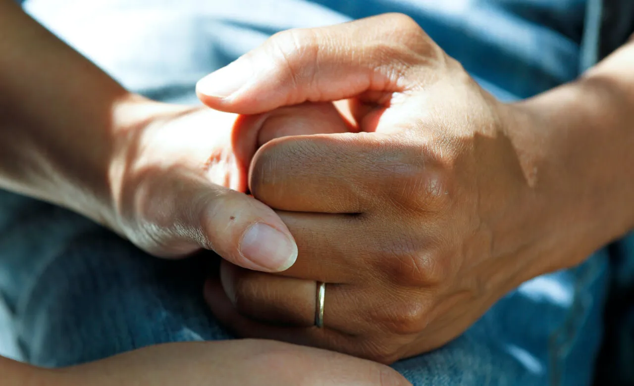Patient holding hands with a loved one