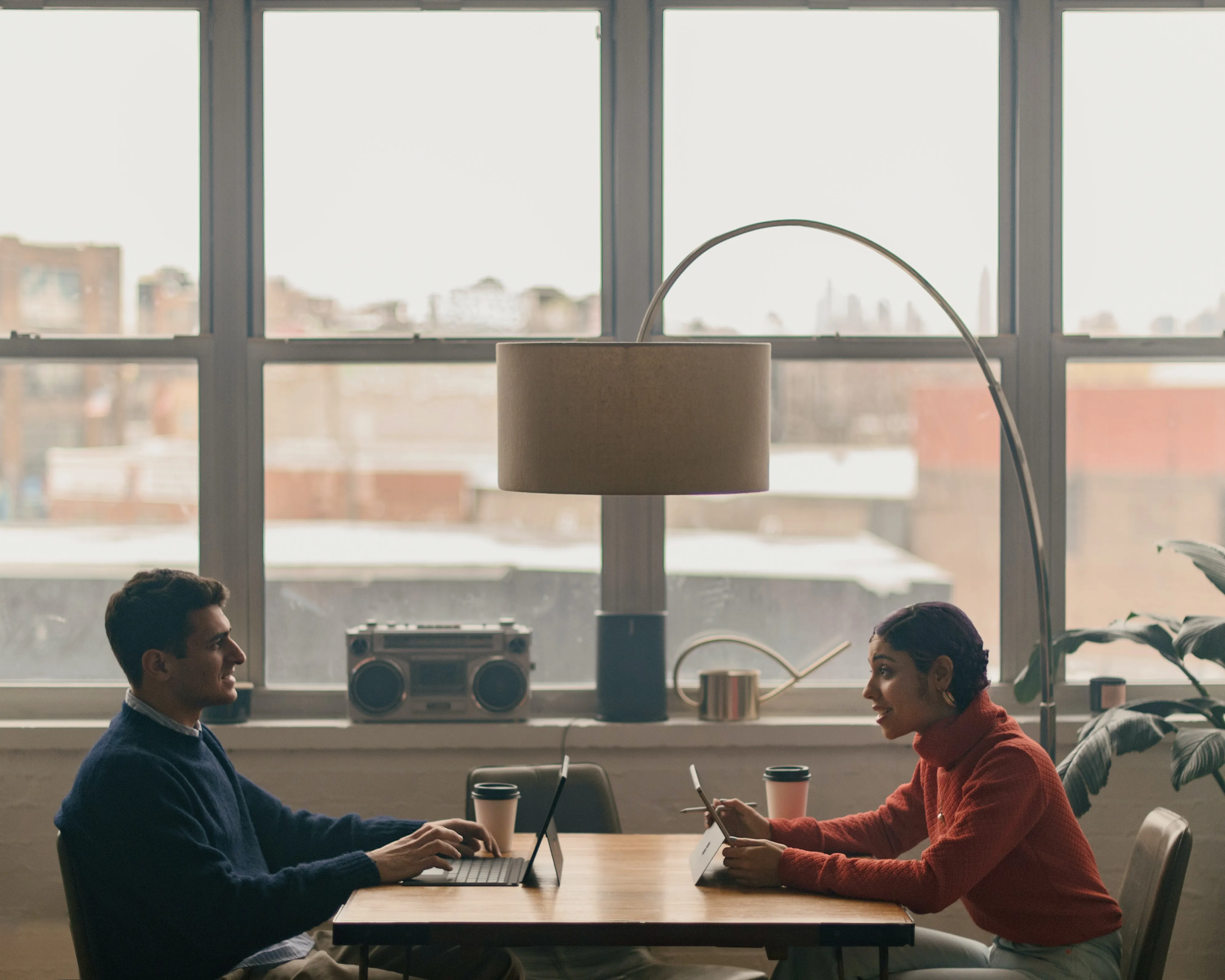 A man and a woman sitting across from each other in a coworking space
