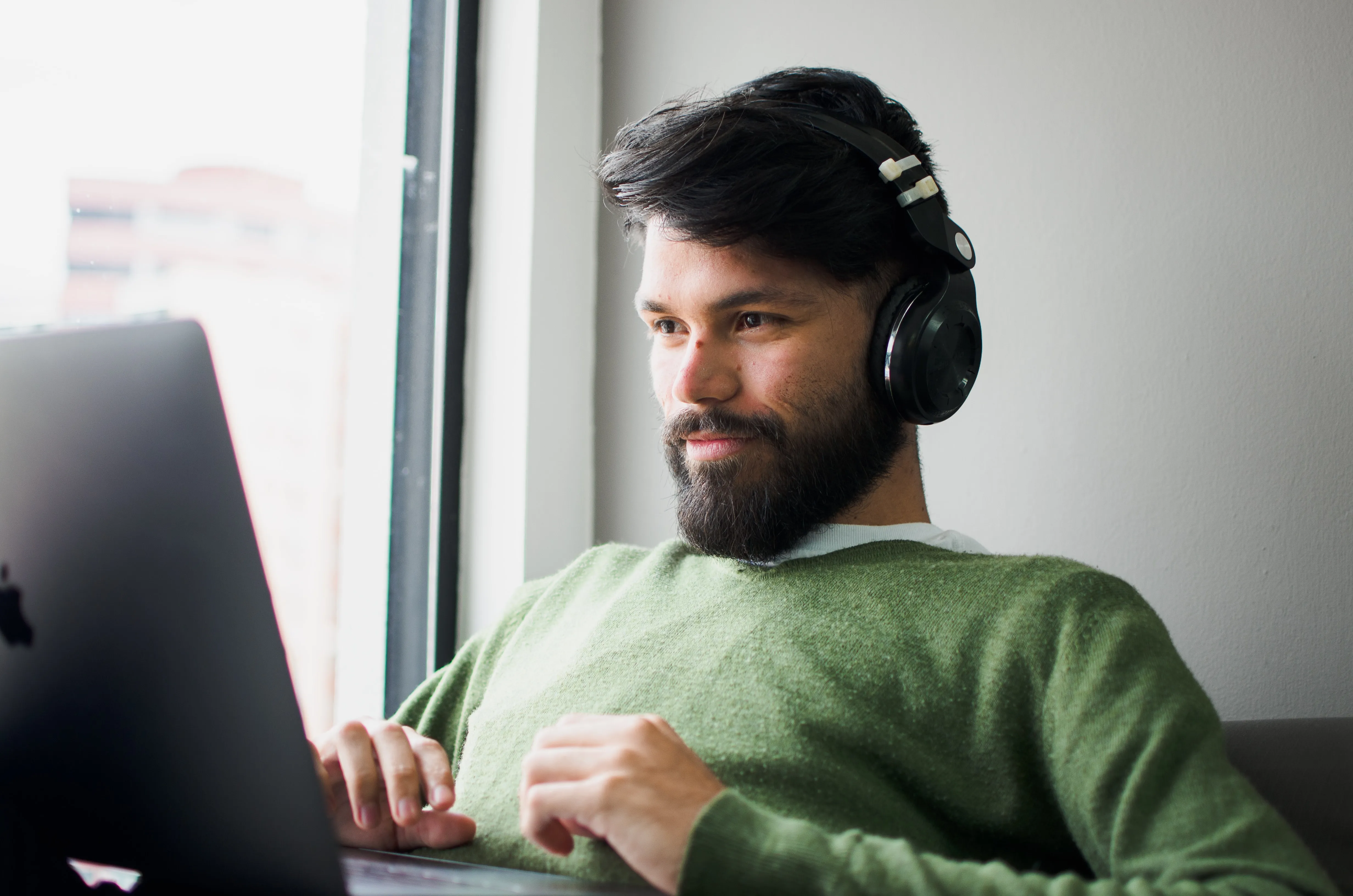 Man at his computer listening to headphones