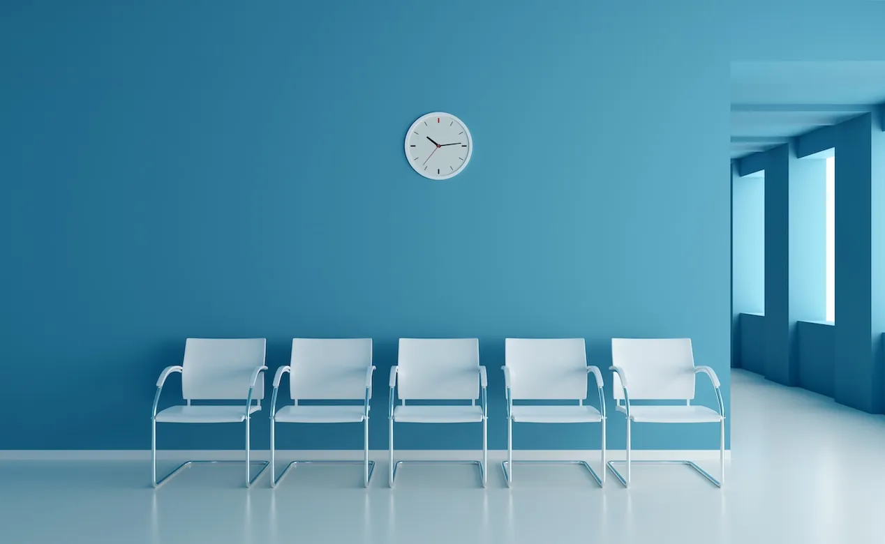 chairs in a waiting room with a clock on the wall