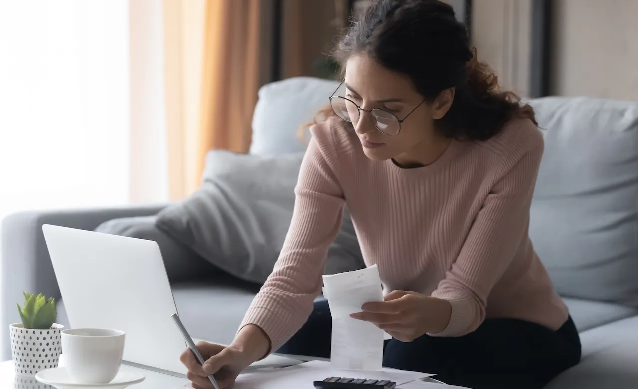 Woman holding receipt and writing something down