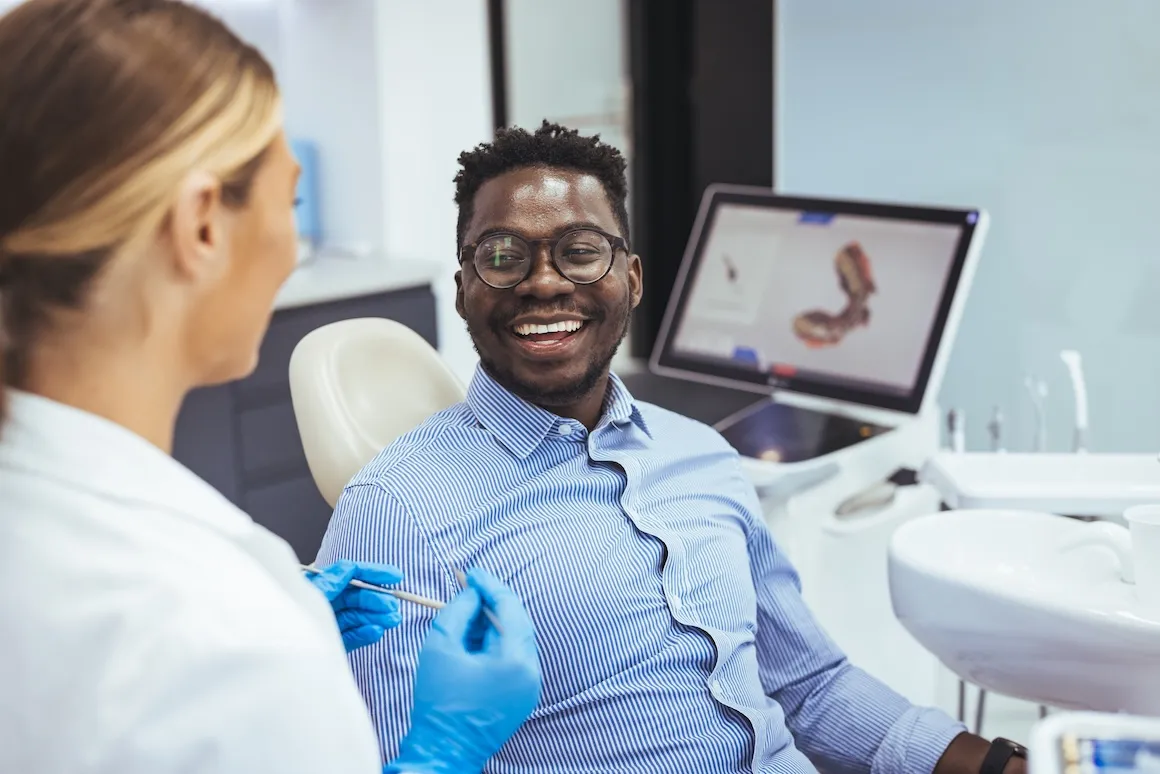 Man at dentist's office getting dental cleaning smiling