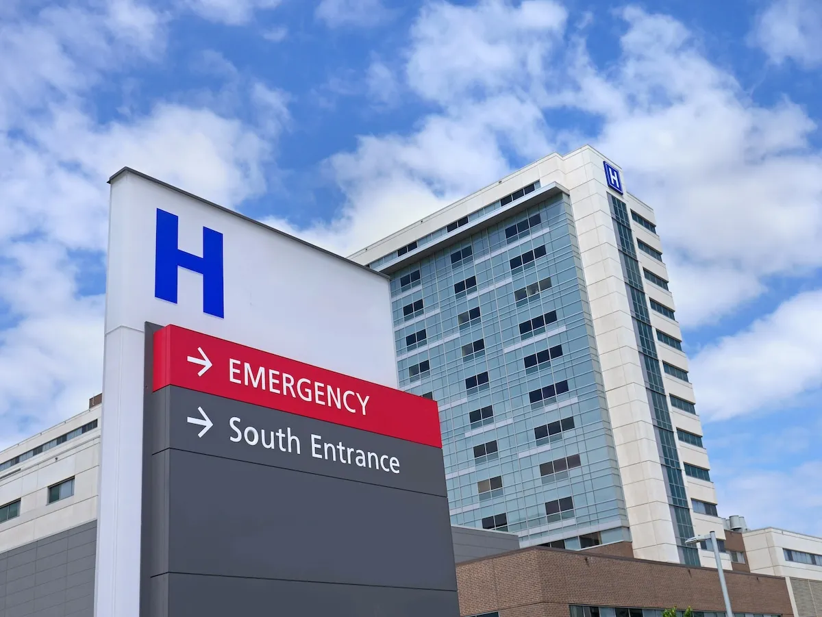 outside of a hospital with a sign directing to the emergency room