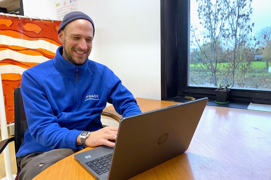 A man smiling on the laptop