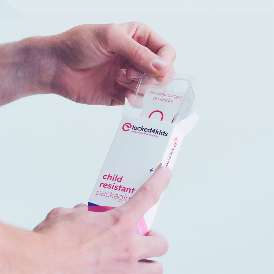 Hand opening Locked4Kids carton, demonstrating the two-action mechanism