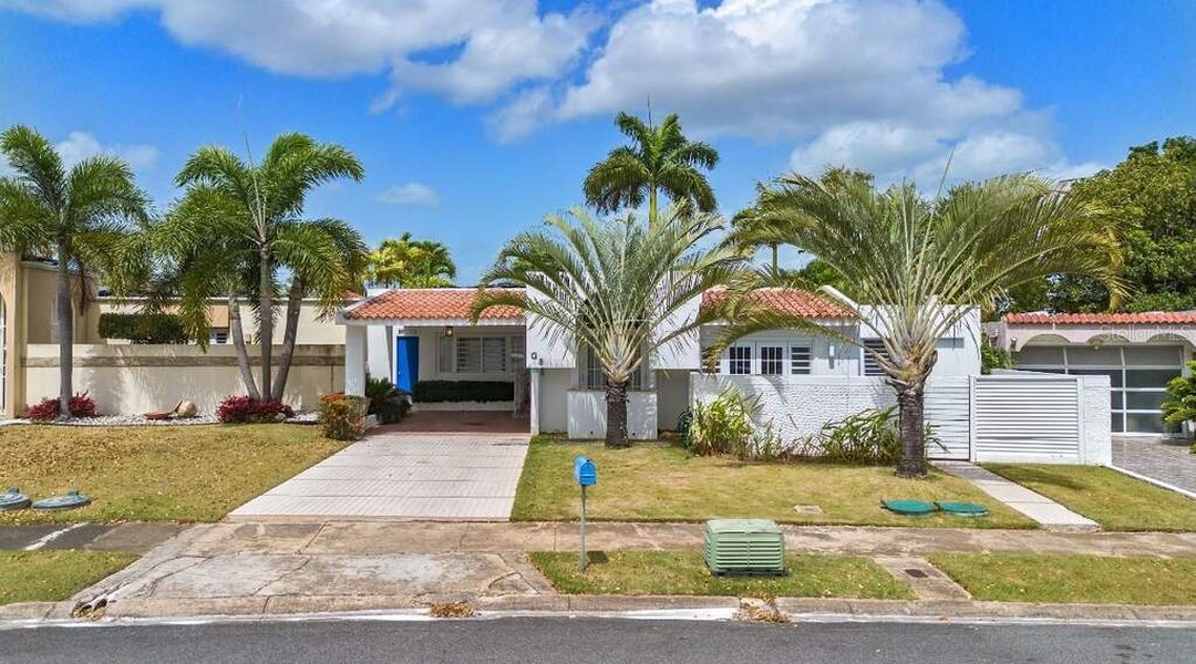 White home with red tiled roof and palm-lined driveway at Dorado Del Mar G8
