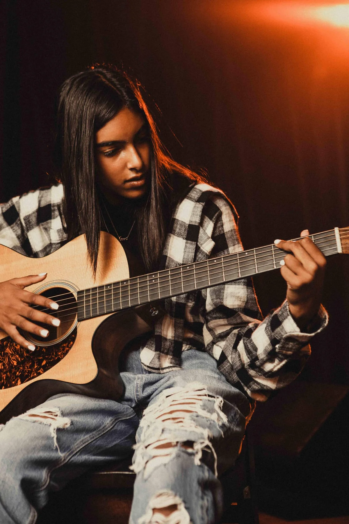 Photo of person playing an acoustic guitar