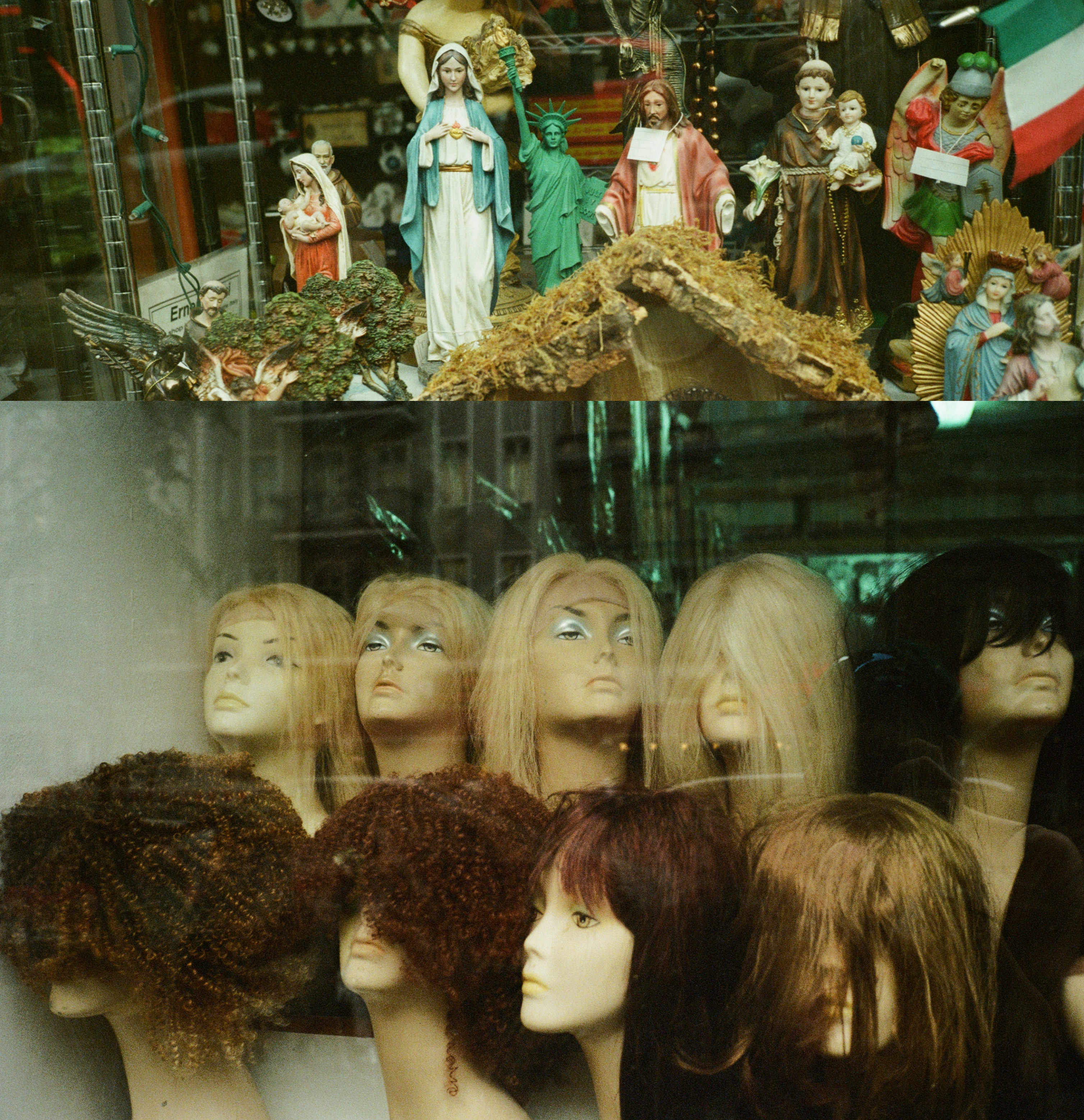 Store display with mannequins wearing various wigs in front and religious statues including the Virgin Mary and Statue of Liberty in the back.