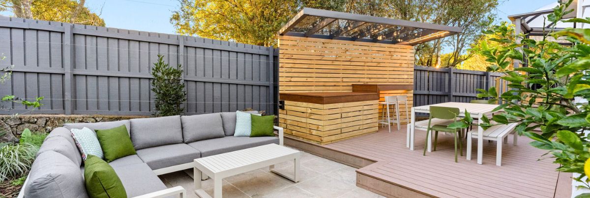 Modern Australian home with a well-designed front garden featuring low-maintenance native plants, clean paths, mulched beds, outdoor seating, and bright landscaping showcasing a property with increased value.